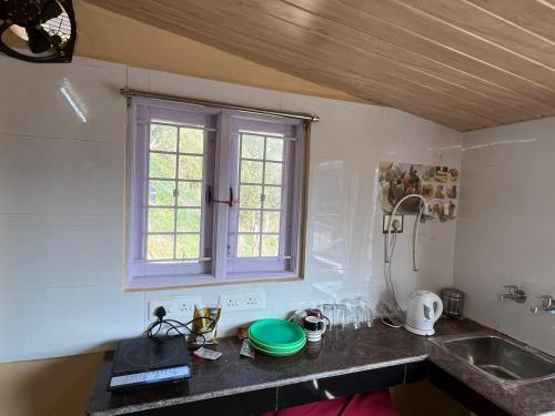 encimera de cocina con fregadero y ventana en Heath cote, en Ooty