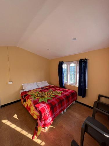 a bedroom with a bed with a plaid blanket at Heath cote in Ooty