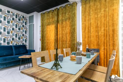une salle à manger avec une table et un canapé bleu dans l'établissement MBA Splendide Appart - Girardot - Montreuil Centre, à Montreuil