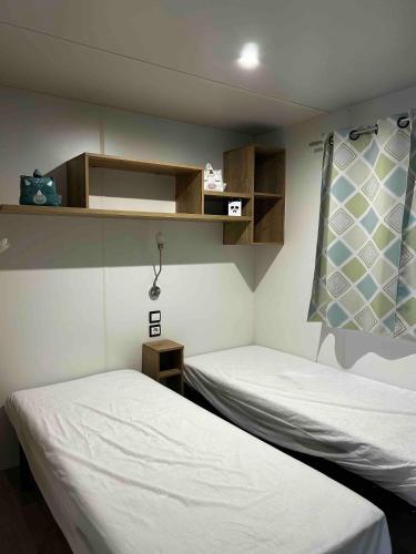 une chambre avec deux lits et une fenêtre dans l'établissement De La Terre A Locean, à Saint-Brévin-les-Pins