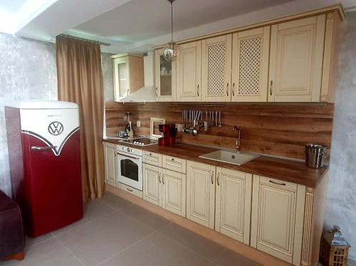 ソゾポルにあるАпартамент Злато изглед МОРЕのキッチン(赤い冷蔵庫、木製キャビネット付)