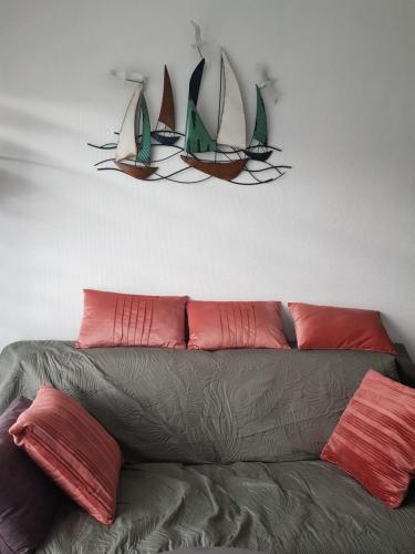 un canapé avec trois voiles sur le mur dans l'établissement Port plage a pied 3nuits mini, au Pouliguen