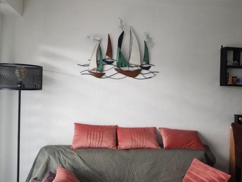 - un salon avec un canapé et des voiles sur le mur dans l'établissement Port plage a pied 3nuits mini, au Pouliguen
