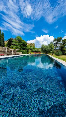 une grande piscine avec un ciel bleu dans l'établissement Château de Villarlong, à Villarzel-Cabardès