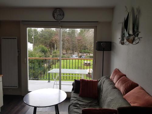 un salon avec un canapé et une porte coulissante en verre dans l'établissement Port plage a pied 3nuits mini, au Pouliguen