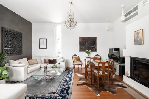 Luxorius apartment on the beach and the citycenter في هلسنكي: غرفة معيشة مع أريكة بيضاء وطاولة