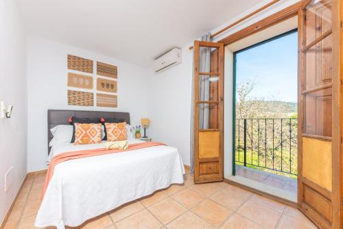 a bedroom with a bed and a large window at Can Antich in Lloseta