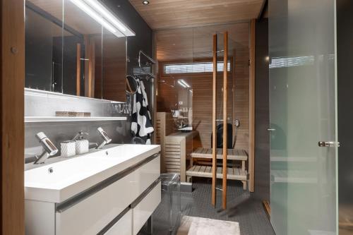 a bathroom with a white sink and a shower at Luxorius apartment on the beach and the citycenter in Helsinki