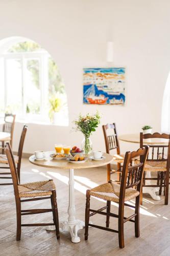 a table with a plate of fruit on it in a dining room at Pelican Hotel in Mýkonos City