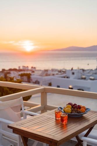 a bowl of fruit sitting on a table on a balcony at Pelican Hotel in Mýkonos City