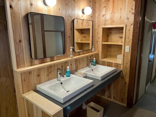 a bathroom with two sinks and a mirror at Ringoya in Hakuba