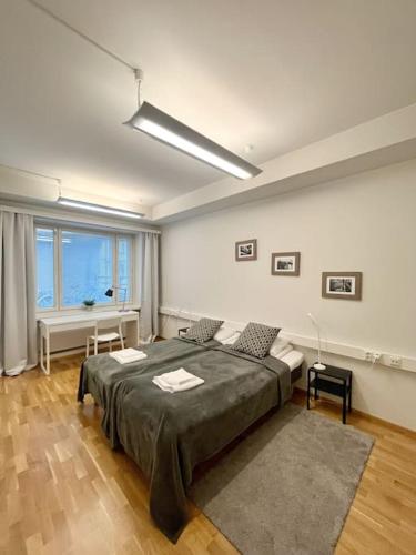 1 dormitorio con cama grande y ventana grande en Kotimaailma Apartments Kamppi - 1BR for 3 persons, en Helsinki