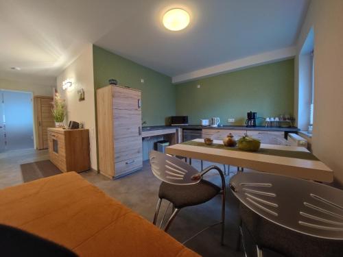 a kitchen with green walls and a table and chairs at Ferienwohnung 1 barrierefrei in Schmiedefeld am Rennsteig