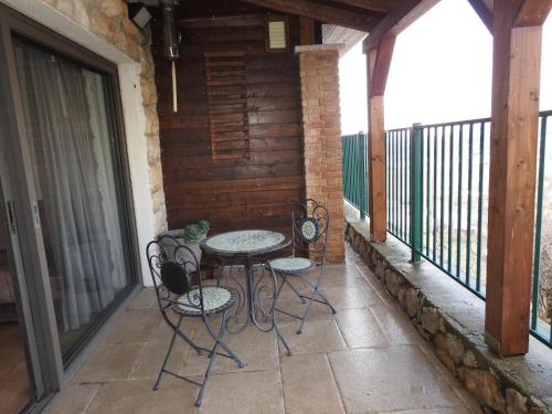 a patio with a table and chairs on a balcony at snowflake.golan in Majdal Shams