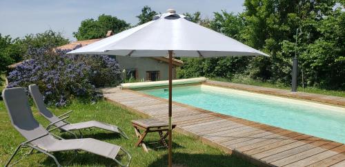 una sombrilla y 2 sillas junto a una piscina en B&B La Ferme de Loubens, en Loubens-Lauragais