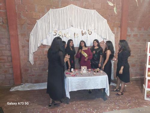 a group of women standing around a table with a cake at AMBAT HOMESTAY in Kottayam