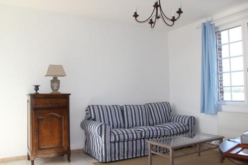 - un salon avec une chaise rayée et une table dans l'établissement Gite Le petit roseau, à Canny-sur-Matz