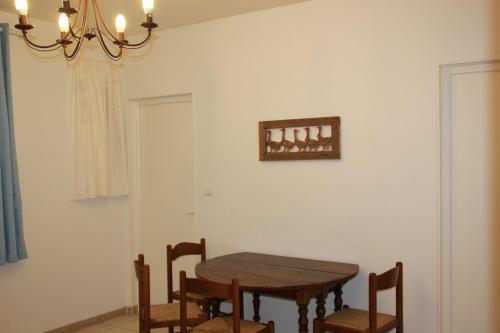 une salle à manger avec une table, des chaises et un lustre dans l'établissement Gite Le petit roseau, à Canny-sur-Matz