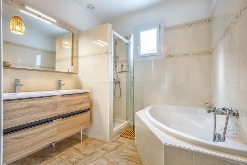 y baño con bañera, ducha y lavamanos. en L'abeliano - House With Pool Near Uzs, en Connaux