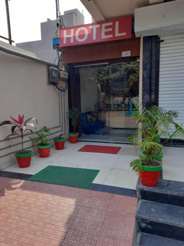 a hotel with potted plants in front of a store at Hotel Sarika International in Indore