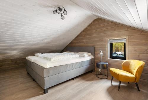 - une chambre avec un lit et une chaise jaune dans l'établissement Stijlvolle vakantiewoning met uitzicht op het Vråvatn meer, à Vradal