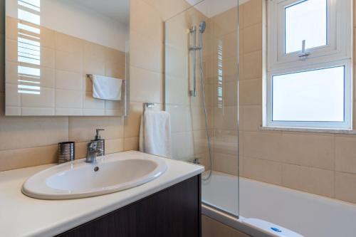 a bathroom with a sink and a shower at Harbor Apartments in Larnaca in Larnaka