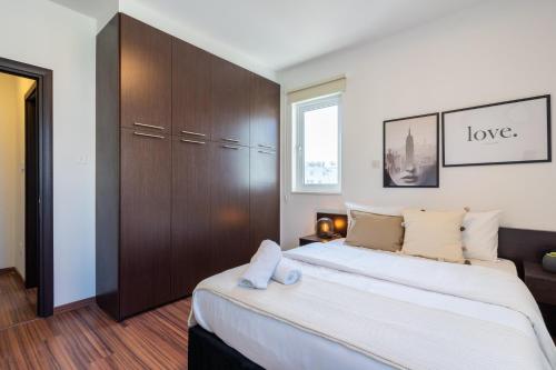 a bedroom with a large bed with a wooden cabinet at Harbor Apartments in Larnaca in Larnaka