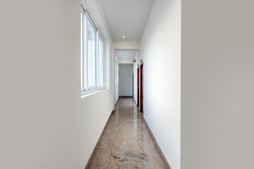 an empty hallway with white walls and a window at Treebo Grace Inn, 3 Min Walk From Promenade Beach in Puducherry