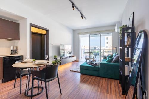 a living room with a table and a green couch at Harbor Apartments in Larnaca in Larnaka