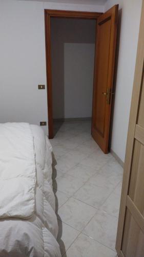 a bedroom with a bed and a door and a tiled floor at Madonna della Libera's House in Avezzano