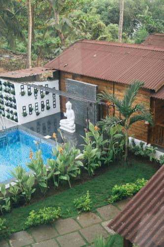 an aerial view of a buddha statue in a garden at Tranquill Riverside Luxury Cottages With Bathtub, Candolim in Candolim
