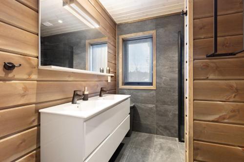 La salle de bains est pourvue d'un lavabo blanc et d'un miroir. dans l'établissement Stijlvolle vakantiewoning met uitzicht op het Vråvatn meer, à Vradal