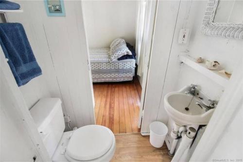 a small bathroom with a toilet and a sink at Cozy Beach - Direct Waterfront! in East Haven