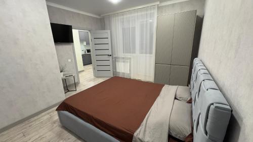 ein Schlafzimmer mit einem Bett und einem TV in der Unterkunft ЖК Отау Сити2 in Kökschetau