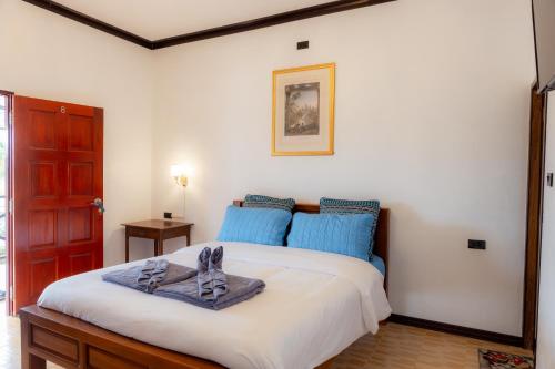 una camera da letto con un grande letto con cuscini blu di Onjira Resort 