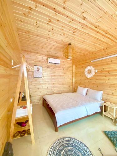 - une chambre avec un lit dans une cabane en bois dans l'établissement TGlobal Anh Dao Tam Dao, à Tam Ðảo
