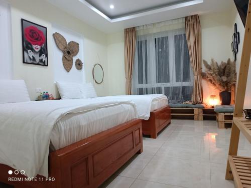 - une chambre avec un grand lit et une fenêtre dans l'établissement TGlobal Anh Dao Tam Dao, à Tam Ðảo
