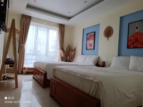 - une chambre avec 2 lits et une fenêtre dans l'établissement TGlobal Anh Dao Tam Dao, à Tam Ðảo