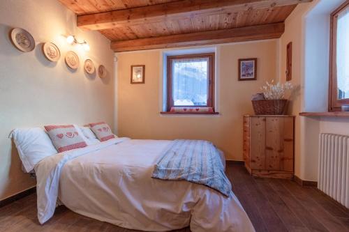 a bedroom with a bed and a window at HelloChalet - Duplex Maison Loz with balcony in Valtournenche