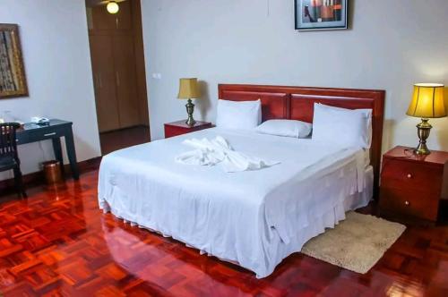 - une chambre avec un grand lit et un couvre-lit blanc dans l'établissement Lidia's Place Guest House, à Maputo