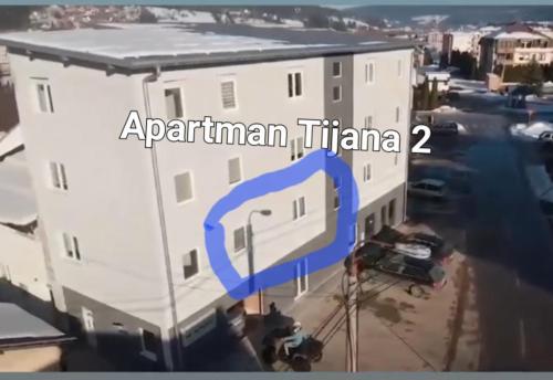un gran edificio blanco con una flecha azul. en Apartman Tijana, en Pale