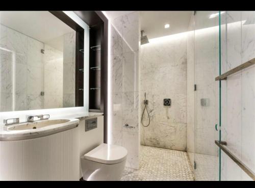 e bagno con servizi igienici, lavandino e doccia. di Trendy, modern 2 bed apartment! a Londra