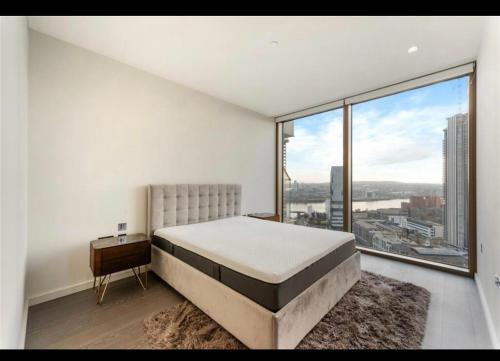 una camera con un letto e una grande finestra di Trendy, modern 2 bed apartment! a Londra