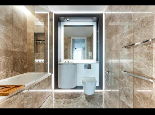 bagno con servizi igienici, lavandino e specchio di Trendy, modern 2 bed apartment! a Londra