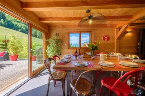une salle à manger en bois avec une table et des chaises dans l'établissement Chalets des Aravis Kitz et Buhel avec Jacuzzi 12 et 15 personnes, à Les Villards-sur-Thônes
