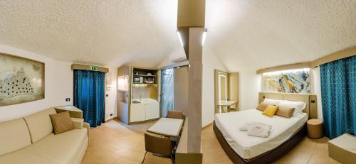 a hotel room with a bed and a couch at Calanica Resort in Cefalù
