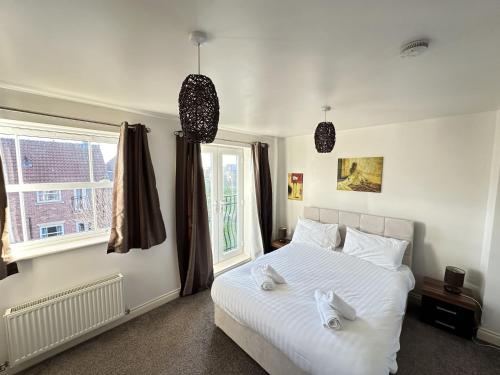 a bedroom with a white bed and a window at Meadowside Apartment in Filey