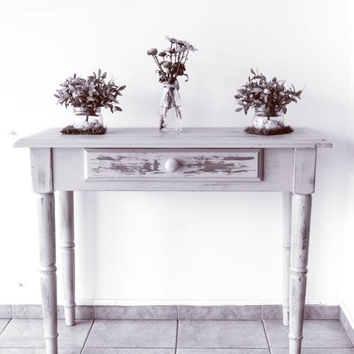 a white table with two plants in vases on it at Hotel Spa El Muelle de Suances in Suances
