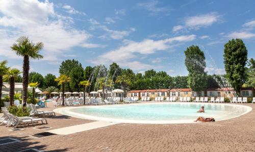 ein Pool in einem Resort mit einer Person schwimmt in der Unterkunft hu Venezia Camping in Town in Marghera