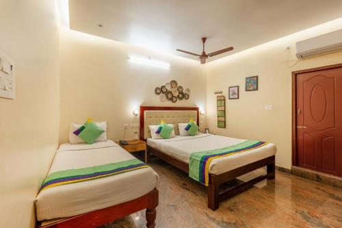 a bedroom with two beds and a ceiling at Treebo Grace Inn, 3 Min Walk From Promenade Beach in Puducherry